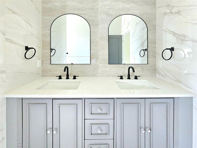 3115 52nd St W, Lehigh Acres, FL 33971 - bathroom with tile walls, double vanity, and tasteful backsplash