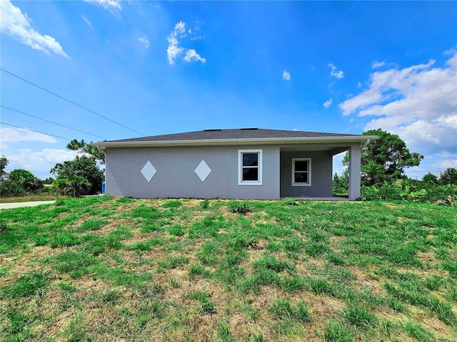 3115 52nd St W, Lehigh Acres, FL 33971 - view of side of home with stucco siding and a lawn