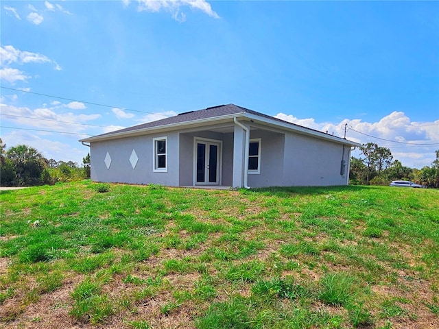 3115 52nd St W, Lehigh Acres, FL 33971 - rear view of property with french doors, stucco siding, and a yard