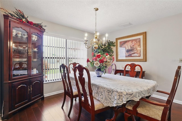 14168 Fennsbury Dr, Tampa, FL 33624 - dining space with baseboards, a chandelier, a textured ceiling, and dark wood-style flooring