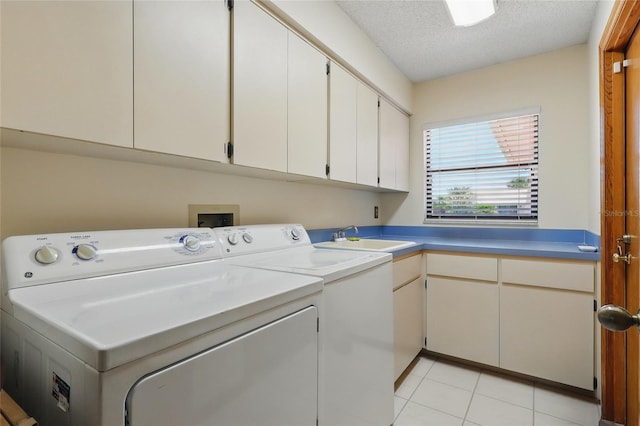 14168 Fennsbury Dr, Tampa, FL 33624 - laundry area with cabinet space, washing machine and dryer, a textured ceiling, and light tile patterned floors
