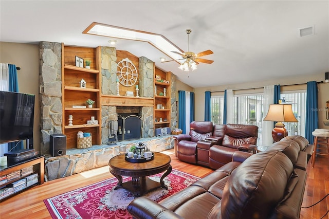 14168 Fennsbury Dr, Tampa, FL 33624 - living room with vaulted ceiling, a ceiling fan, wood finished floors, a skylight, and a fireplace