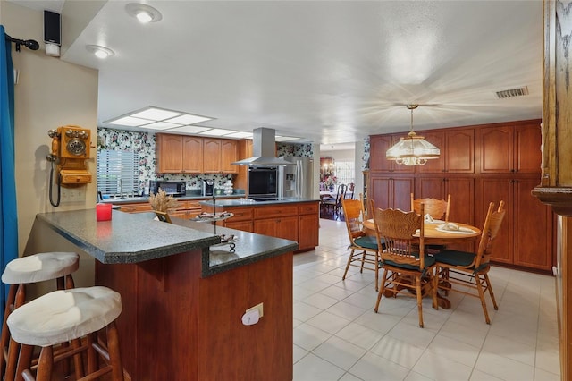 14168 Fennsbury Dr, Tampa, FL 33624 - kitchen featuring island range hood, black microwave, dark countertops, a peninsula, and a breakfast bar area
