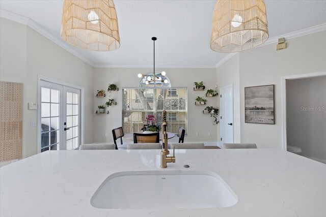 230 Columbia Dr, Tampa, FL 33606 - kitchen with crown molding, a sink, light stone countertops, a chandelier, and hanging light fixtures