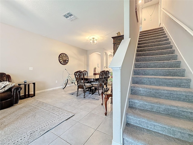841 Royal Empress Dr, Ruskin, FL 33570 - stairs with arched walkways, tile patterned flooring, and baseboards