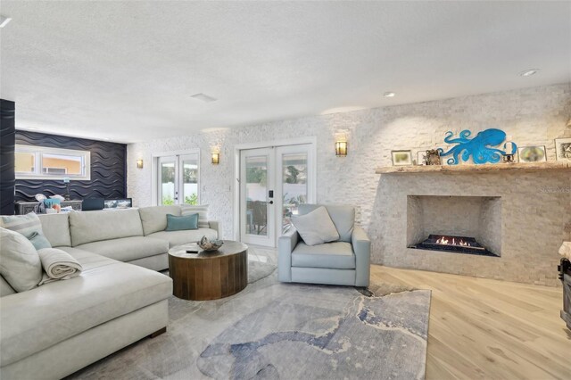 931 Gulf Blvd, Belleair Beach, FL 33786 - living room featuring a lit fireplace, wood finished floors, and french doors