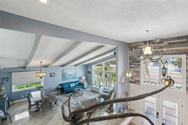 931 Gulf Blvd, Belleair Beach, FL 33786 - living room featuring a chandelier, wood finished floors, plenty of natural light, a textured ceiling, and baseboards