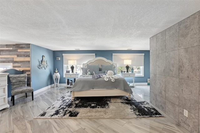 931 Gulf Blvd, Belleair Beach, FL 33786 - bedroom featuring an accent wall, wood finished floors, baseboards, and a textured ceiling