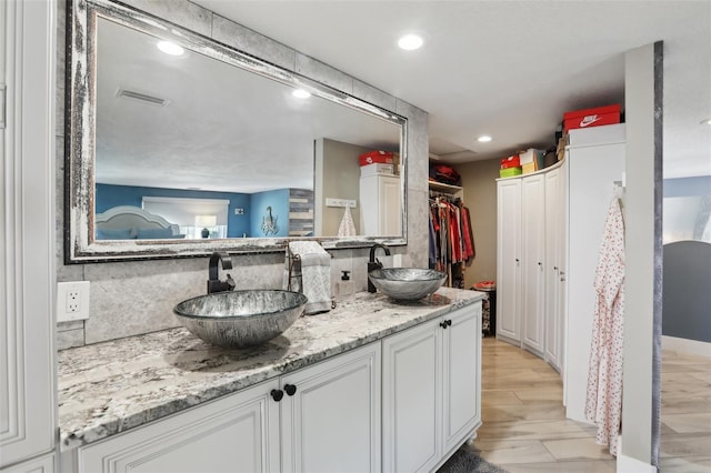 931 Gulf Blvd, Belleair Beach, FL 33786 - kitchen with a sink, decorative backsplash, white cabinets, recessed lighting, and light stone counters