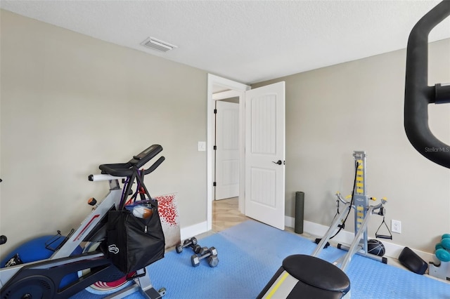 931 Gulf Blvd, Belleair Beach, FL 33786 - workout room featuring baseboards and a textured ceiling