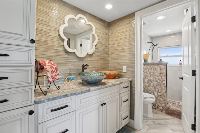 931 Gulf Blvd, Belleair Beach, FL 33786 - bathroom with tile walls, toilet, vanity, a stall shower, and backsplash