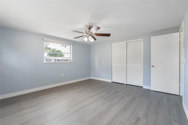 5027 Overton Dr, New Port Richey, FL 34652 - unfurnished bedroom with a closet, wood finished floors, and a ceiling fan