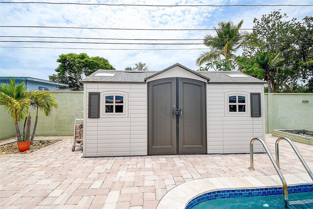 5672 62nd Way N, Saint Petersburg, FL 33709 - view of shed with a fenced backyard and a swimming pool