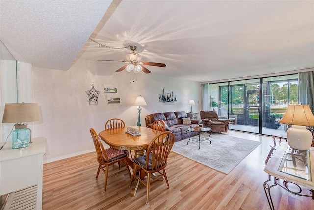 14130 Rosemary Ln Unit 4115, Largo, FL 33774 - dining room featuring a ceiling fan, a wall of windows, light wood-style floors, and baseboards