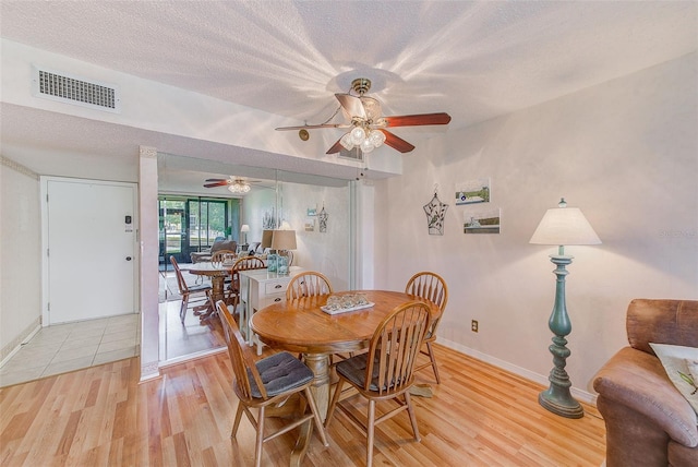 14130 Rosemary Ln Unit 4115, Largo, FL 33774 - dining area featuring light wood-style floors, ceiling fan, baseboards, and a textured ceiling
