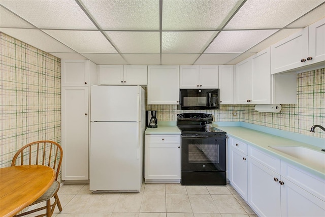 14130 Rosemary Ln Unit 4115, Largo, FL 33774 - kitchen with black appliances, a sink, a drop ceiling, light tile patterned floors, and light countertops