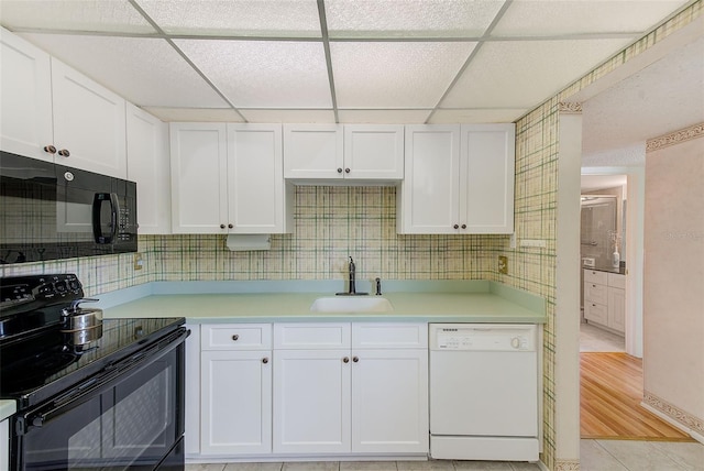 14130 Rosemary Ln Unit 4115, Largo, FL 33774 - kitchen with black appliances, a sink, light countertops, white cabinetry, and a drop ceiling