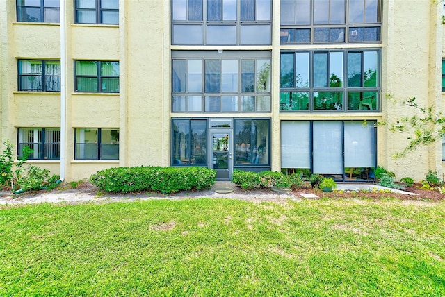 14130 Rosemary Ln Unit 4115, Largo, FL 33774 - doorway to property featuring stucco siding and a lawn
