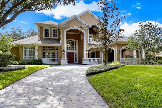 704 Berrocales De Avila, Tampa, FL 33613 - view of front of property with stucco siding, a front yard, decorative driveway, and a balcony