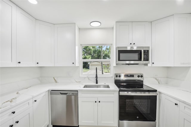2220 3rd Ave E, Bradenton, FL 34208 - kitchen with stainless steel appliances, a sink, and white cabinetry