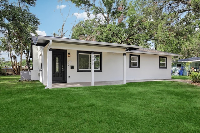 2220 3rd Ave E, Bradenton, FL 34208 - view of front of house with stucco siding, a front yard, a patio, and central AC unit