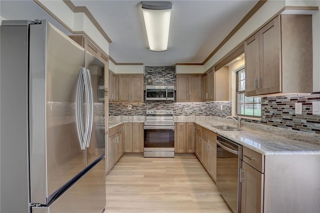5201 E Jasmine Ln, Inverness, FL 34453 - kitchen featuring appliances with stainless steel finishes, a sink, light wood-type flooring, light stone counters, and tasteful backsplash