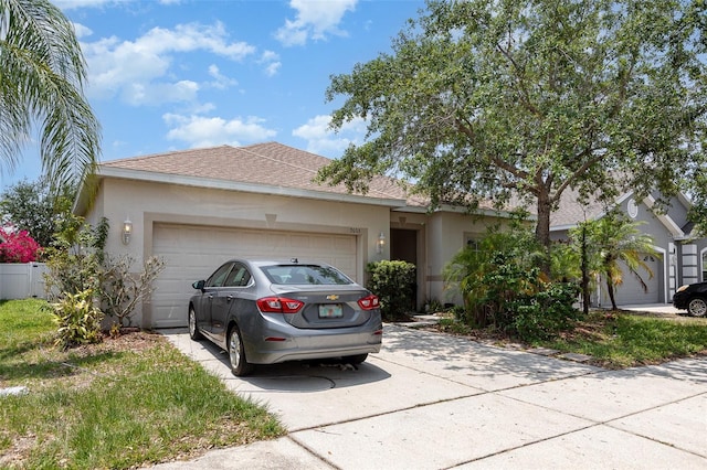 7603 Wood Violet Dr, Gibsonton, FL 33534 - single story home with concrete driveway, an attached garage, stucco siding, and a shingled roof