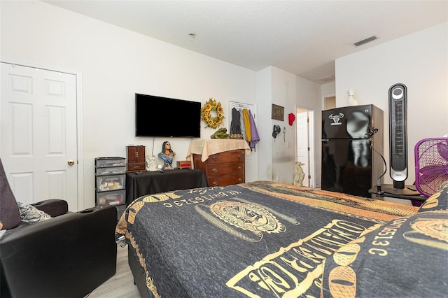 7603 Wood Violet Dr, Gibsonton, FL 33534 - bedroom featuring freestanding refrigerator and wood finished floors