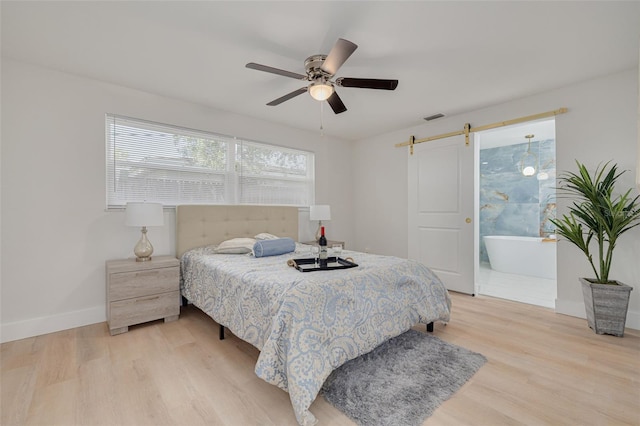 11296 115th St, Largo, FL 33778 - bedroom featuring a barn door, light wood finished floors, baseboards, and ceiling fan