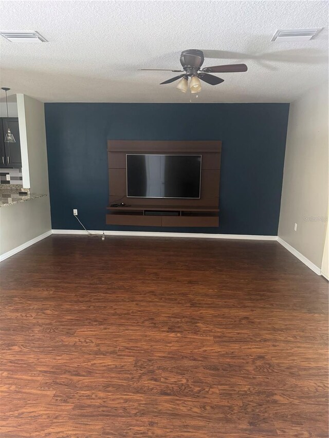 9833 Hound Chase Dr, Gibsonton, FL 33534 - unfurnished living room with wood finished floors, a ceiling fan, a textured ceiling, and baseboards