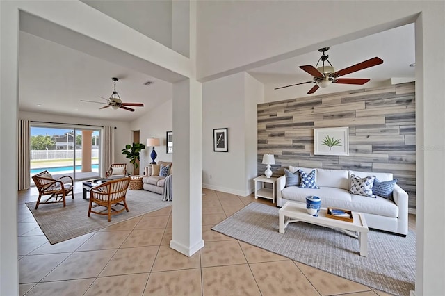 6425 Clair Shore Dr, Apollo Beach, FL 33572 - living room featuring an accent wall, a ceiling fan, wood walls, tile patterned flooring, and baseboards