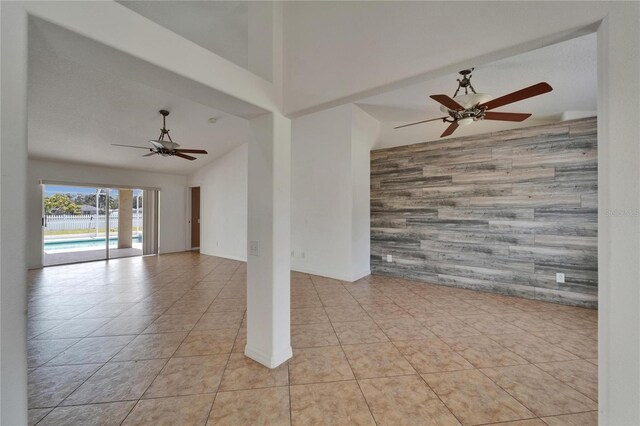 6425 Clair Shore Dr, Apollo Beach, FL 33572 - tiled empty room with an accent wall, ceiling fan, and wood walls