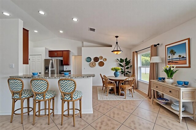 6425 Clair Shore Dr, Apollo Beach, FL 33572 - kitchen featuring stainless steel fridge with ice dispenser, light tile patterned floors, a peninsula, a kitchen breakfast bar, and hanging light fixtures