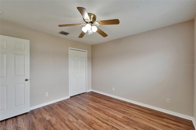 6425 Clair Shore Dr, Apollo Beach, FL 33572 - unfurnished bedroom with wood finished floors, baseboards, a closet, and ceiling fan
