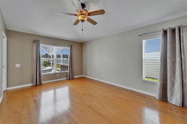6425 Clair Shore Dr, Apollo Beach, FL 33572 - unfurnished room featuring ceiling fan, light wood-type flooring, baseboards, and a textured ceiling