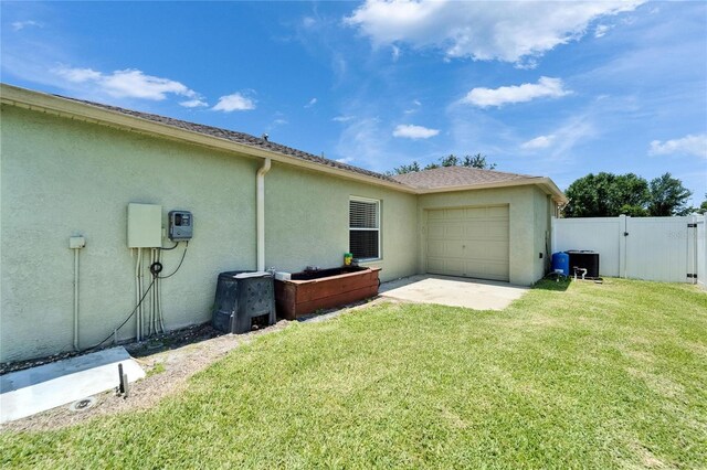 6425 Clair Shore Dr, Apollo Beach, FL 33572 - view of side of property with stucco siding, an attached garage, and a gate