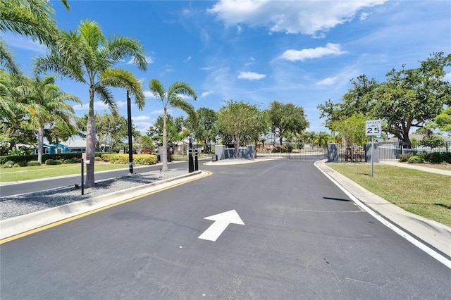 6425 Clair Shore Dr, Apollo Beach, FL 33572 - view of asphalt street featuring curbs, traffic signs, a gate, and a gated entry