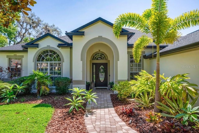 15934 Sorawater Dr, Lithia, FL 33547 - view of exterior entry featuring stucco siding and roof with shingles