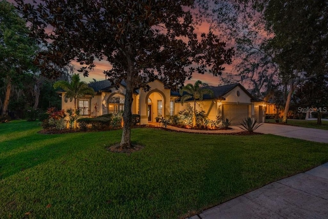 15934 Sorawater Dr, Lithia, FL 33547 - view of front of home featuring stucco siding, concrete driveway, a yard, and a garage