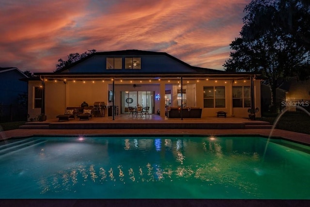 15934 Sorawater Dr, Lithia, FL 33547 - pool at dusk featuring an outdoor pool, a patio area, and an outdoor living space