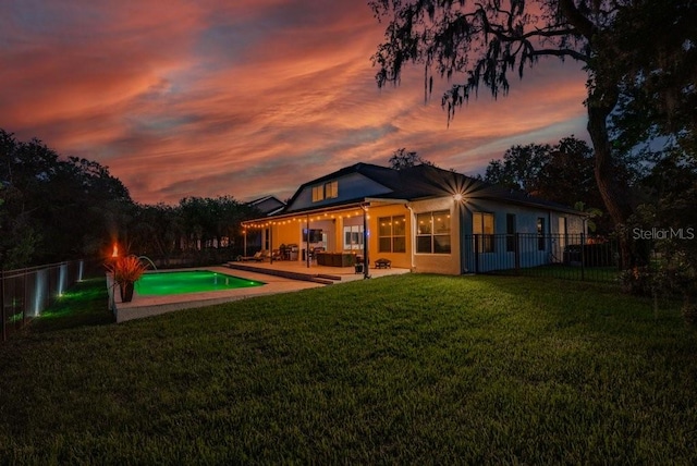 15934 Sorawater Dr, Lithia, FL 33547 - back of house at dusk featuring a fenced backyard and a patio