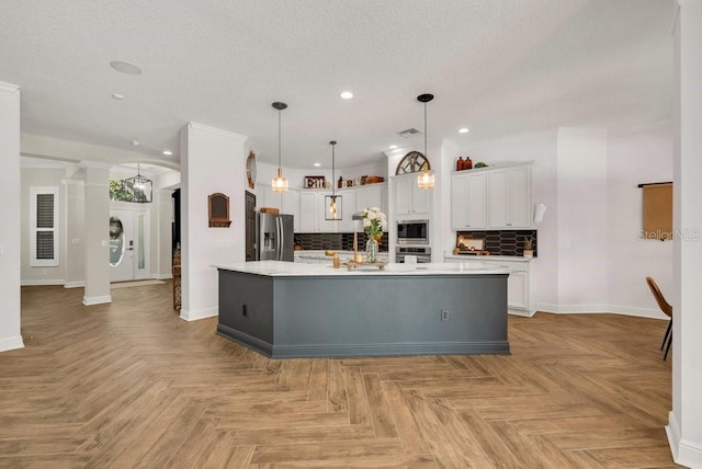 15934 Sorawater Dr, Lithia, FL 33547 - kitchen featuring appliances with stainless steel finishes, white cabinetry, light countertops, tasteful backsplash, and recessed lighting