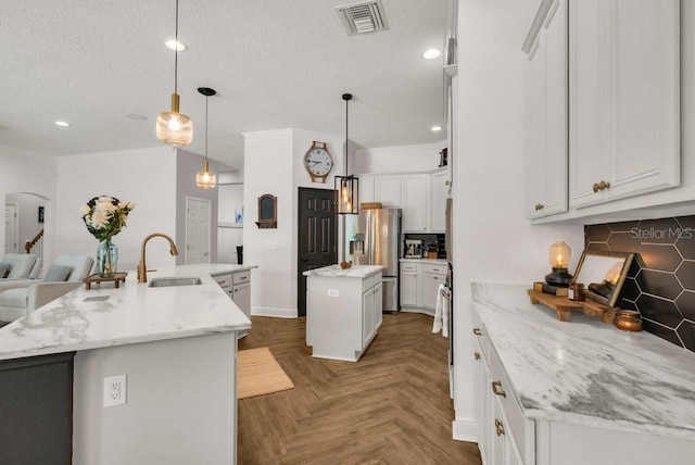 15934 Sorawater Dr, Lithia, FL 33547 - kitchen with a large island with sink, stainless steel refrigerator with ice dispenser, backsplash, recessed lighting, and a textured ceiling