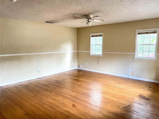 403 E Carolina Ave, Plant City, FL 33563 - empty room featuring hardwood / wood-style floors, ceiling fan, plenty of natural light, a textured ceiling, and baseboards