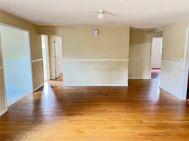 403 E Carolina Ave, Plant City, FL 33563 - spare room featuring light wood-type flooring, a textured ceiling, and baseboards