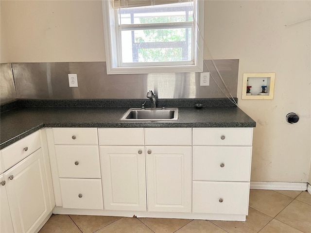 403 E Carolina Ave, Plant City, FL 33563 - kitchen with a sink, light tile patterned floors, dark countertops, and white cabinets