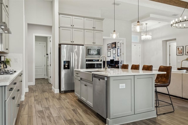5314 Alafia Falls Dr, Lithia, FL 33547 - kitchen featuring appliances with stainless steel finishes, light countertops, light wood finished floors, open floor plan, and a breakfast bar