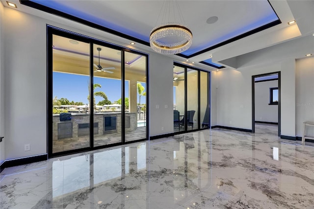 6522 Simone Shores Cir, Apollo Beach, FL 33572 - unfurnished room with marble tiled flooring, baseboards, a ceiling fan, and a raised ceiling