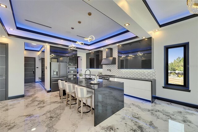 6522 Simone Shores Cir, Apollo Beach, FL 33572 - kitchen featuring wall chimney exhaust hood, a raised ceiling, modern cabinets, and appliances with stainless steel finishes