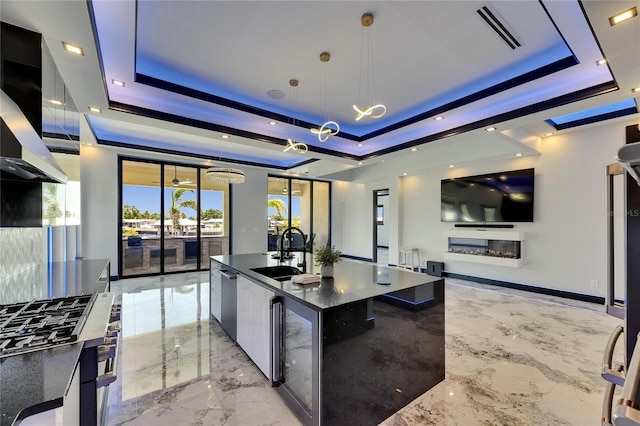 6522 Simone Shores Cir, Apollo Beach, FL 33572 - kitchen with a tray ceiling, a sink, light marble finish floors, beverage cooler, and modern cabinets